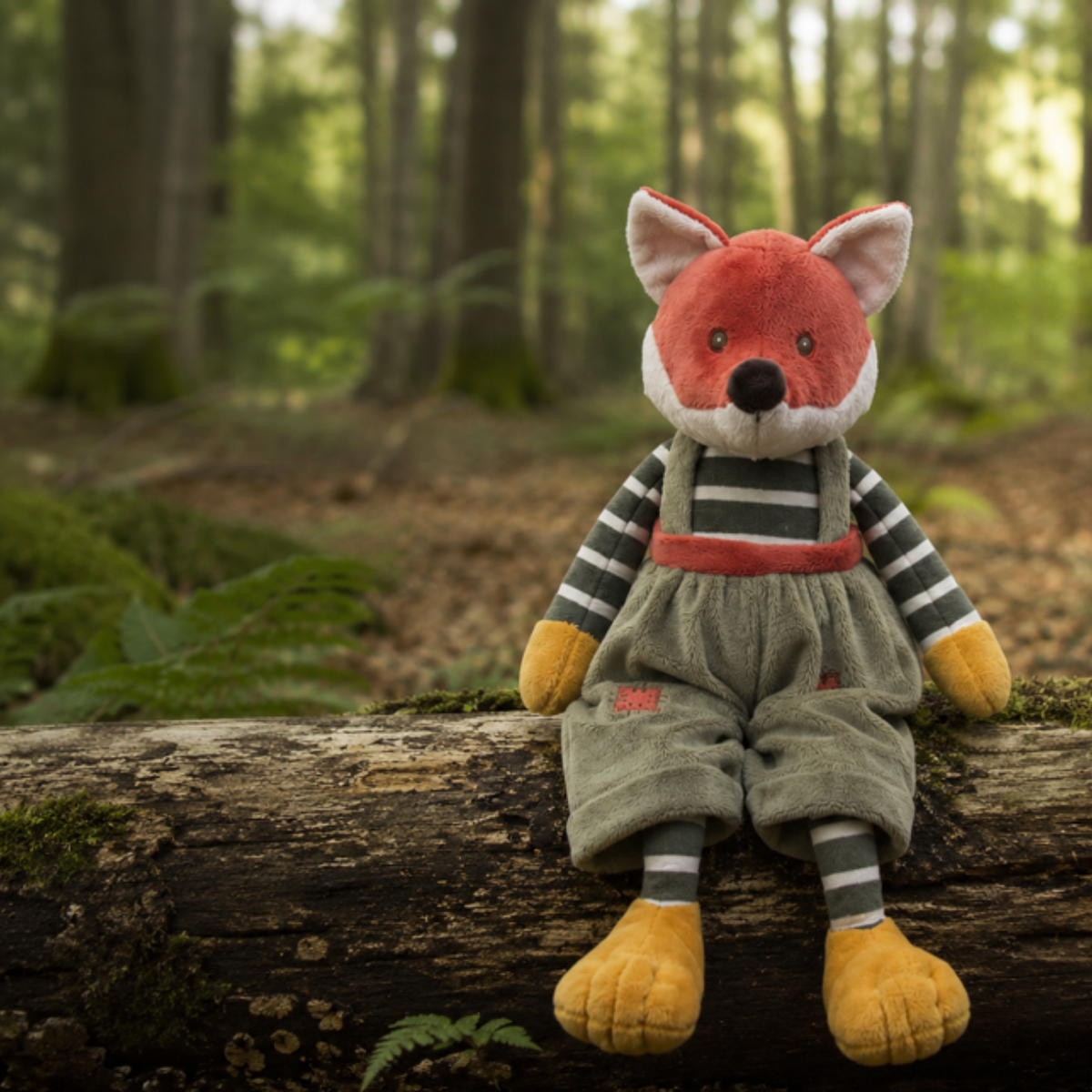 Great Foxy knuffel zittend op een boomstam in een bos