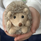 Hubert opgerold knuffelegeltje 15 cm van Bukowski Sweden in hand van kind