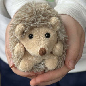 Hubert opgerold knuffelegeltje 15 cm van Bukowski Sweden in hand van kind
